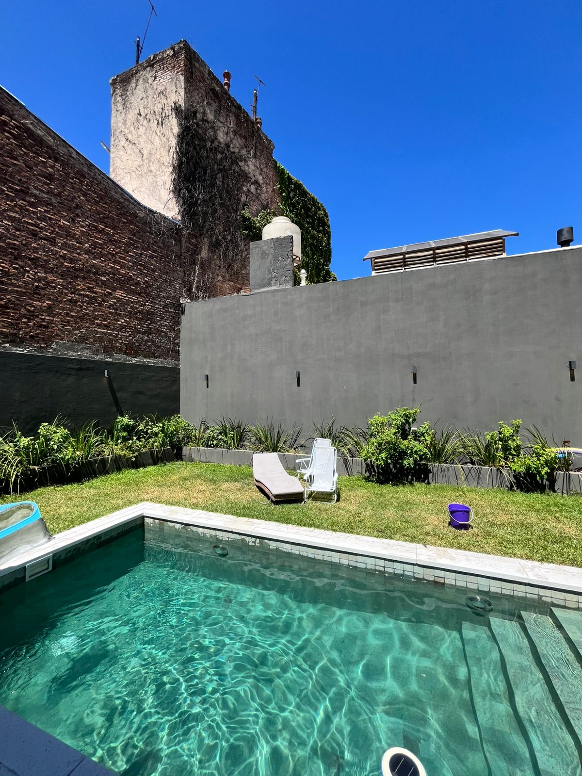 Piscina moderna con agua cristalina y jardín
